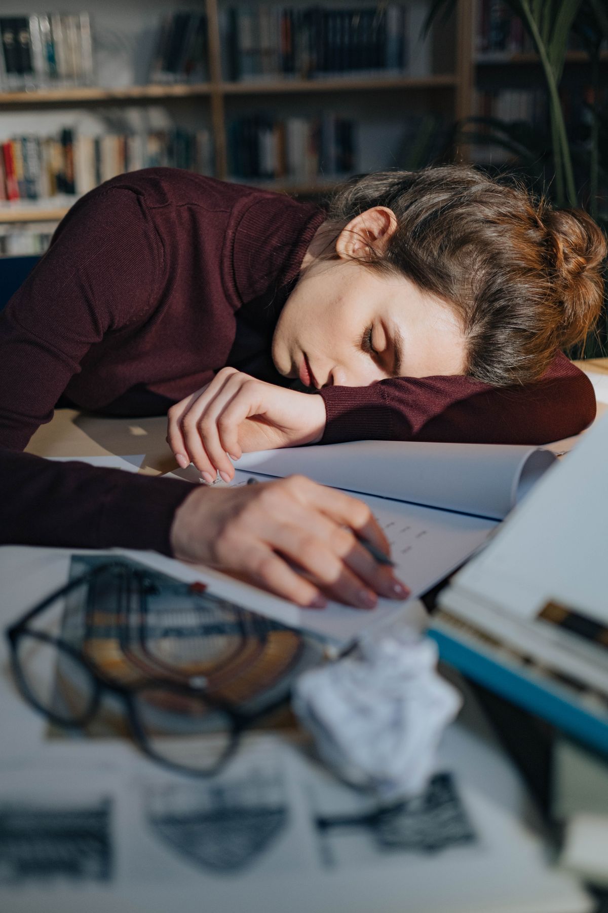 A tired person resting their head at a desk
